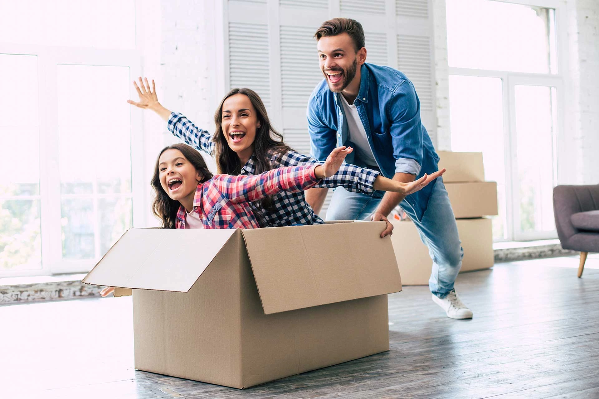 family moving in being playful with a box